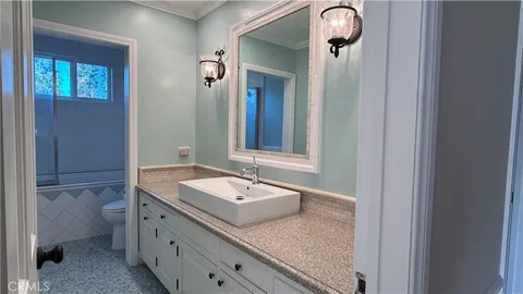a bathroom with a granite countertop sink and a mirror
