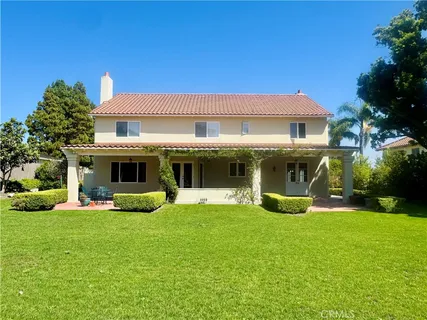 a view of a house with a big yard and potted plants