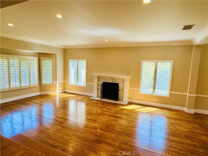 a view of empty room with wooden floor and fireplace