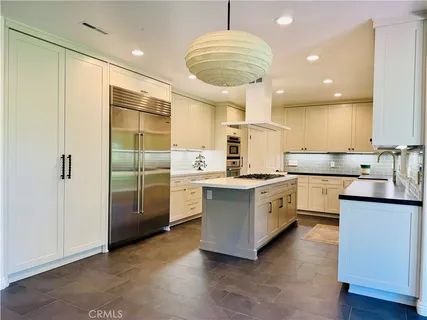 a kitchen with white cabinets and sink