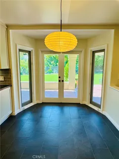 a view of an empty room with glass door and a window