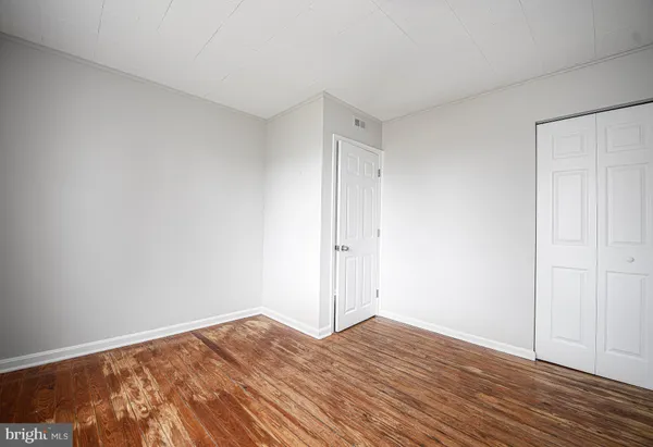 a view of empty room with wooden floor