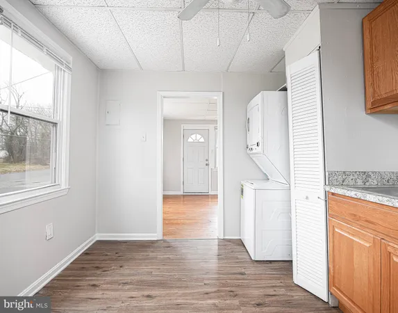 a view of hallway with wooden floor and cabinet
