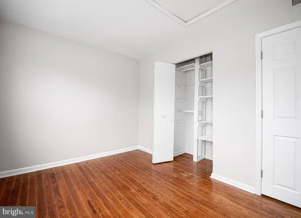 a view of empty room with wooden floor