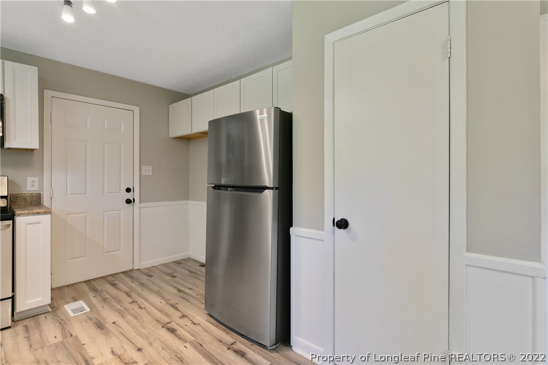 711 Bronco Road Fayetteville, NC 28303 - Photo 16 of 42 a view of a refrigerator in kitchen and white cabinets
