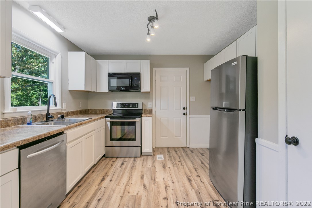 711 Bronco Road Fayetteville, NC 28303 - Photo 17 of 42 a kitchen with a refrigerator and a sink