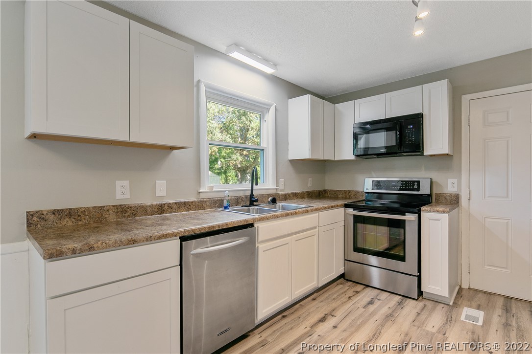 711 Bronco Road Fayetteville, NC 28303 - Photo 18 of 42 a kitchen with stainless steel appliances granite countertop a stove a sink and a microwave