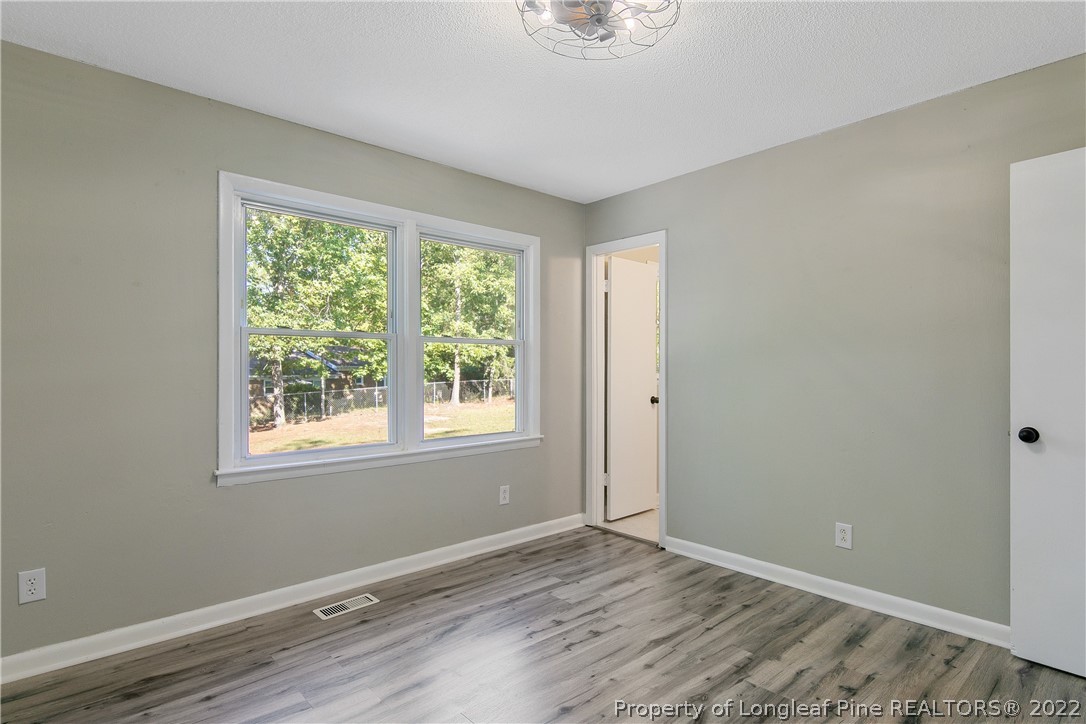 711 Bronco Road Fayetteville, NC 28303 - Photo 23 of 42 a view of an empty room with wooden floor and a window