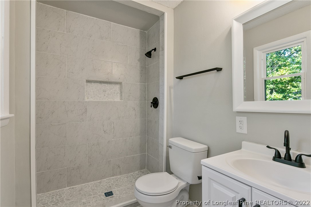 711 Bronco Road Fayetteville, NC 28303 - Photo 26 of 42 a bathroom with a sink a toilet and shower
