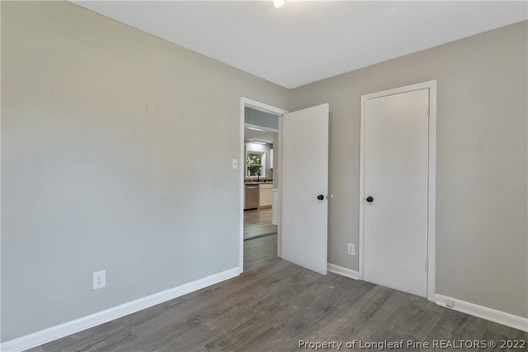 711 Bronco Road Fayetteville, NC 28303 - Photo 31 of 42 a view of an empty room with closet and wooden floor