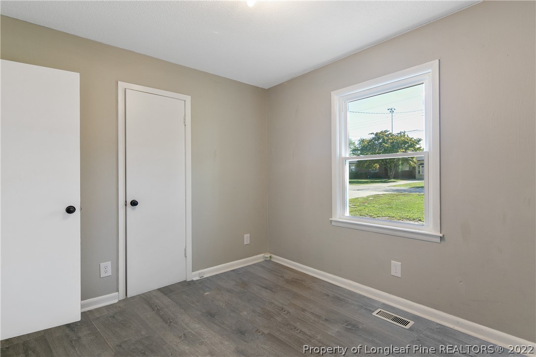 711 Bronco Road Fayetteville, NC 28303 - Photo 32 of 42 a view of an empty room with wooden floor and a window