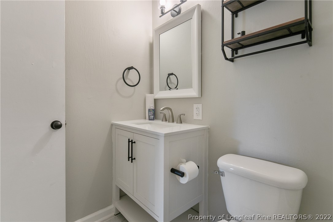 711 Bronco Road Fayetteville, NC 28303 - Photo 34 of 42 a bathroom with a toilet sink and mirror
