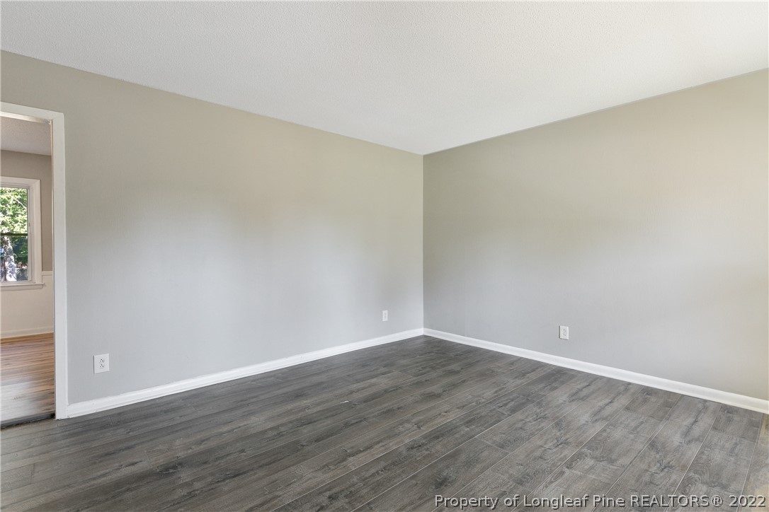 711 Bronco Road Fayetteville, NC 28303 - Photo 6 of 42 a view of an empty room with wooden floor and a window