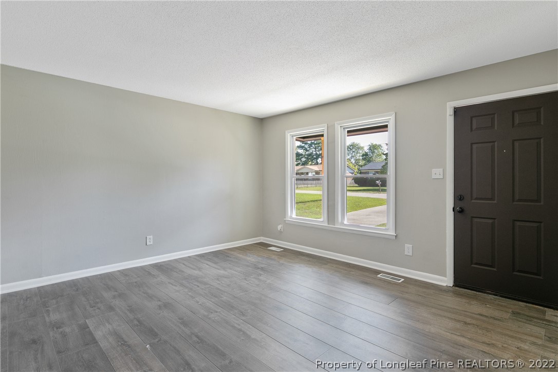 711 Bronco Road Fayetteville, NC 28303 - Photo 7 of 42 an empty room with wooden floor and windows