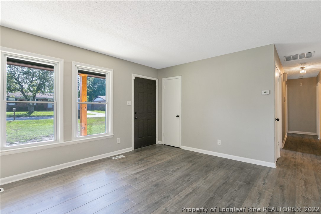 711 Bronco Road Fayetteville, NC 28303 - Photo 8 of 42 a view of an empty room with wooden floor and a window