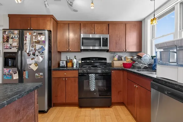 a kitchen with stainless steel appliances granite countertop a refrigerator and a stove top oven