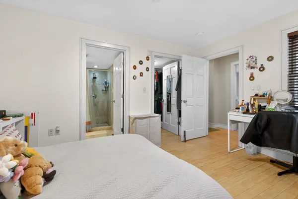 a bedroom with a bed and large mirror in a room