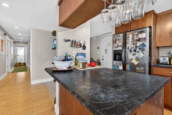 a kitchen with stainless steel appliances granite countertop a sink a refrigerator and a stove