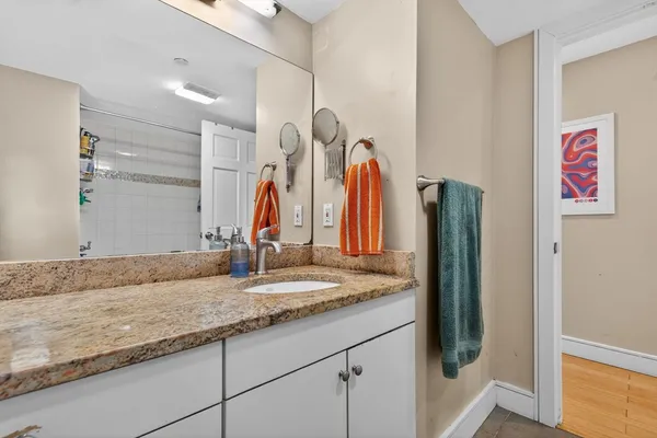 a bathroom with a granite countertop sink and a mirror