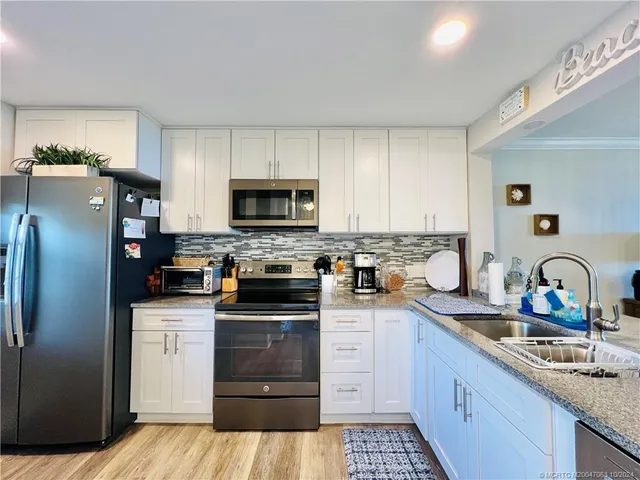 a kitchen with stainless steel appliances granite countertop a stove and a refrigerator