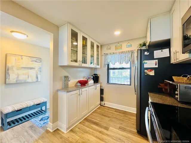 a kitchen with a sink stainless steel appliances and white cabinets