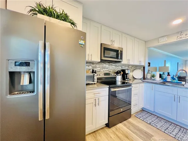 a kitchen with sink a stove and cabinets