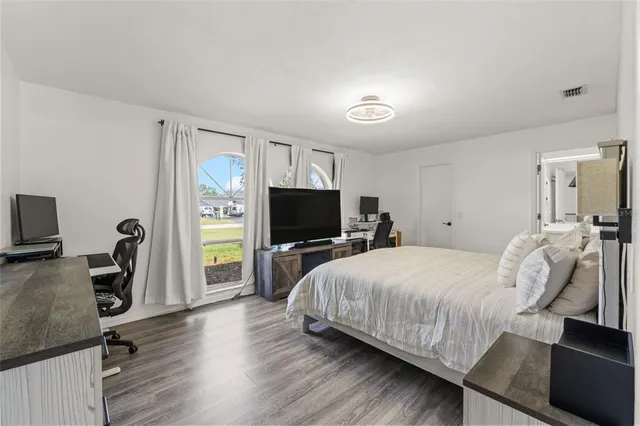 a bedroom with a bed and a flat screen tv