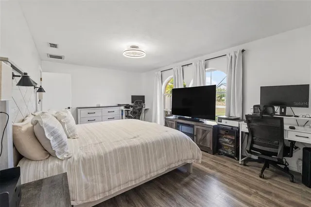 a bedroom with a bed and a flat screen tv