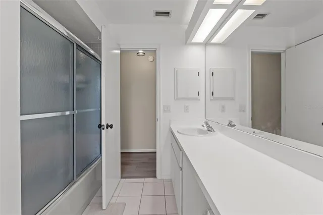a spacious bathroom with a shower sink and mirror
