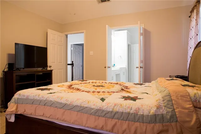 a bedroom with a bed and a flat screen tv