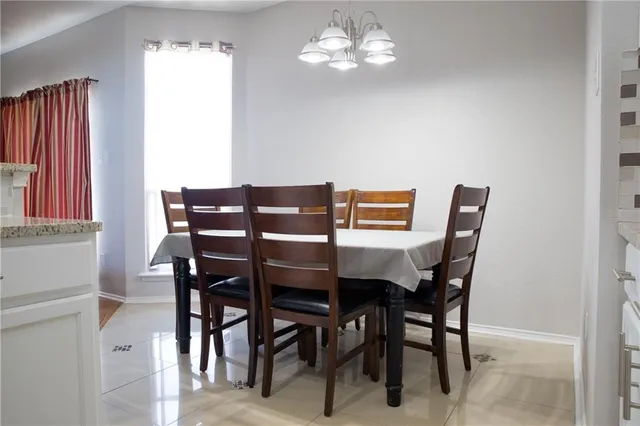 a view of a dining room with furniture and chandelier