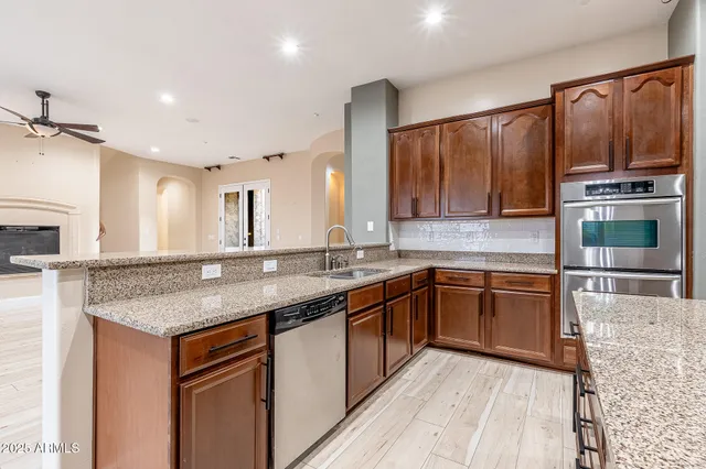 a kitchen with stainless steel appliances granite countertop a sink stove and cabinets