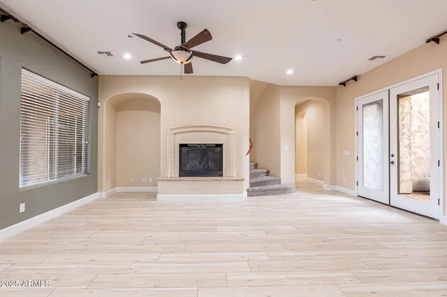 a view of an empty room with a fireplace and a window