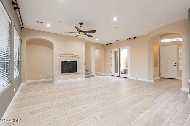 a view of an empty room with a fireplace and a window