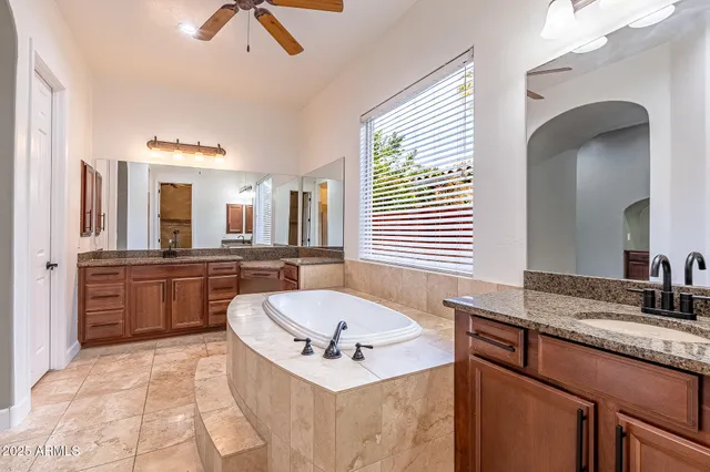 a bathroom with a granite countertop sink mirror and bathtub
