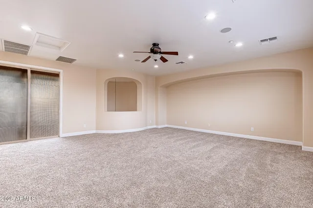 an empty room with windows and fan