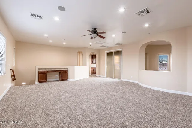 a view of a livingroom with a fireplace and a chandelier fan