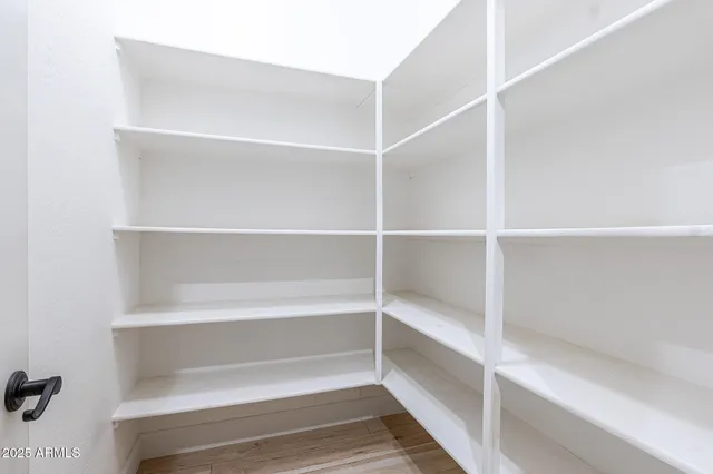 a view of walk in closet with empty racks