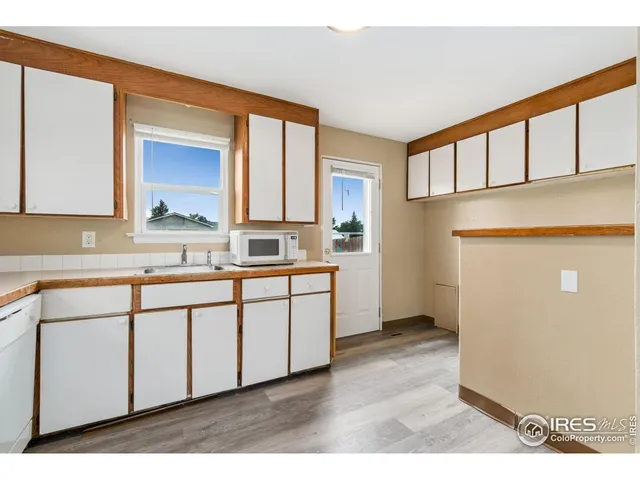 a kitchen with granite countertop white cabinets and white appliances