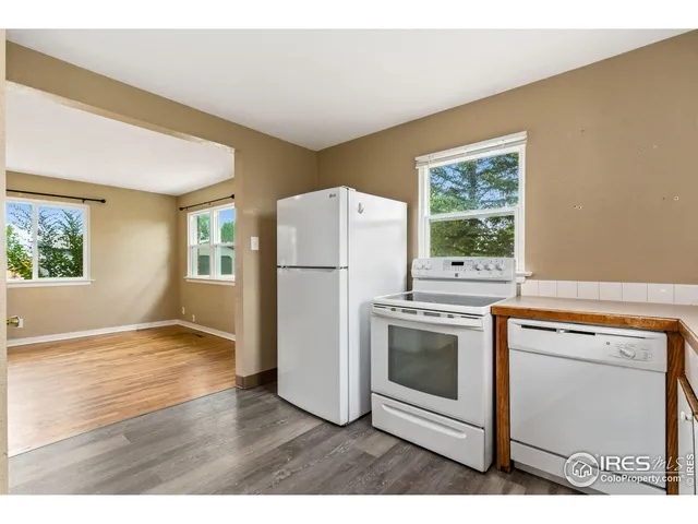 a kitchen with a stove a refrigerator and a wooden floor