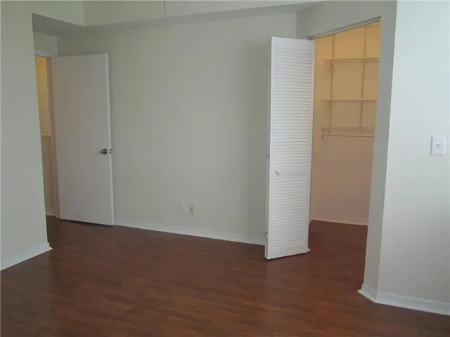 an empty room with wooden floor and closet