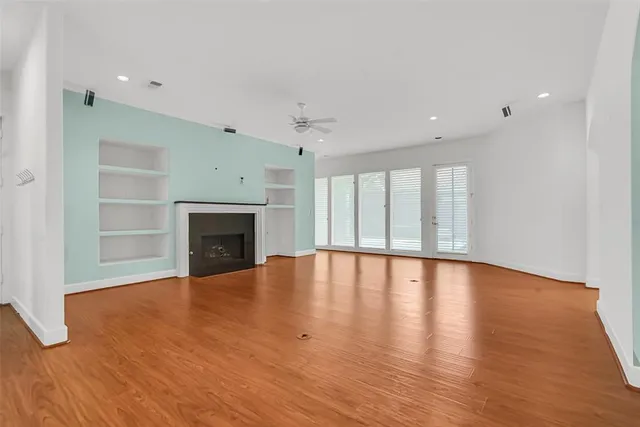 a view of empty room with wooden floor and fireplace