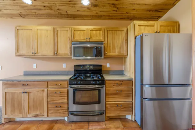 a kitchen with stainless steel appliances wooden cabinets and a stove top oven