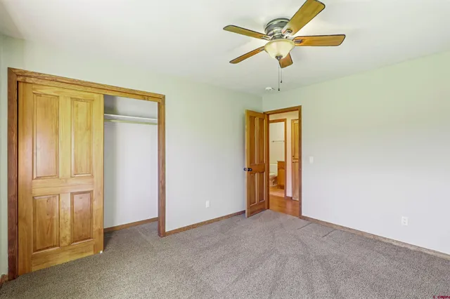 a view of a room with a ceiling fan and a window