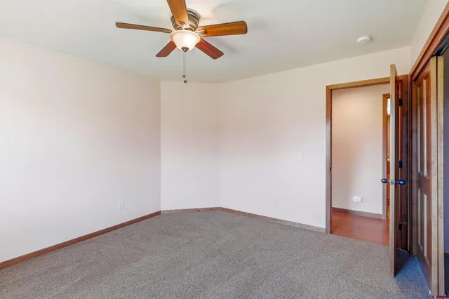 a view of a room with a ceiling fan and a fan