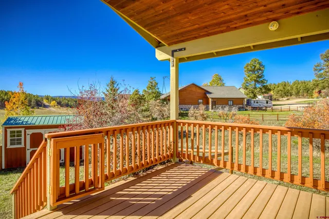 a view of a balcony with wooden floor and outdoor seating