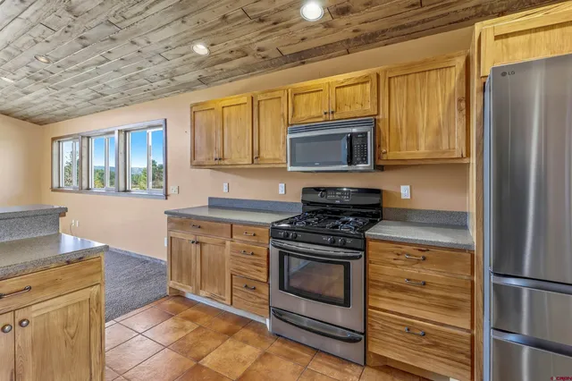 a kitchen with stainless steel appliances granite countertop a stove microwave and refrigerator