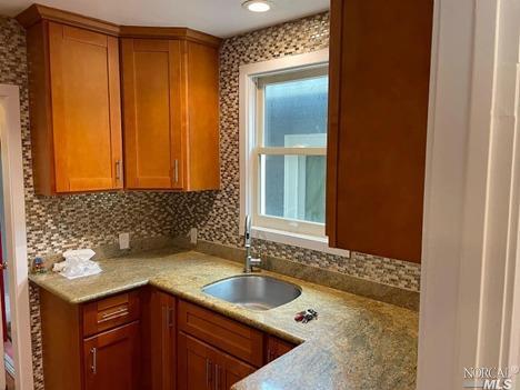 a bathroom with a granite countertop sink and a bathtub