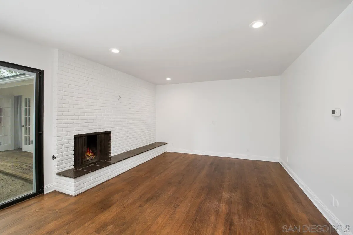 6229 La Jolla Mesa Drive La Jolla, CA 92037 - Photo 13 of 39 a view of an empty room with wooden floor and a fireplace