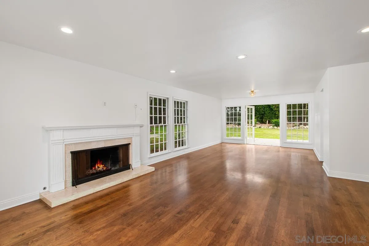 6229 La Jolla Mesa Drive La Jolla, CA 92037 - Photo 10 of 39 a view of an empty room with wooden floor fireplace and a window